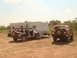1992 Ford Bronco - A brown 1992 Ford Bronco is parked in a dirt lot next to a white Jeep and a travel trailer.