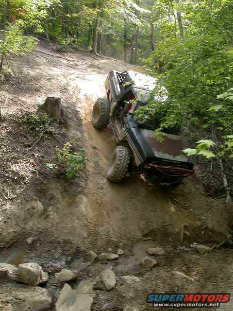 Black SUV climbing steep dirt hill off-road