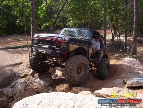 Black 1978 Ford Bronco off-roading over rocks