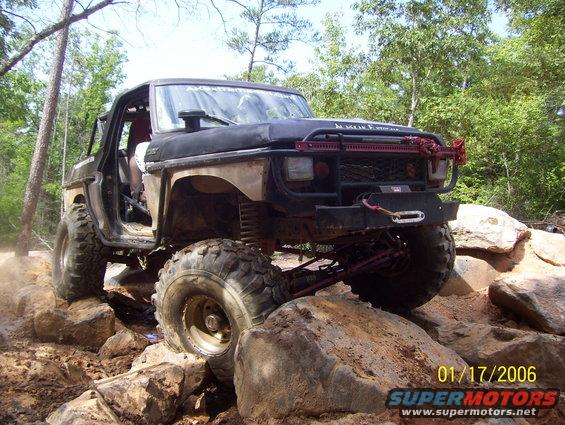 Black 1978 Ford Bronco off-roading over rocks