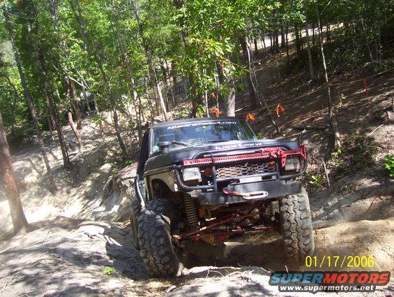 1978 Ford Bronco with red off-road bumper and winch, driving on a dirt trail