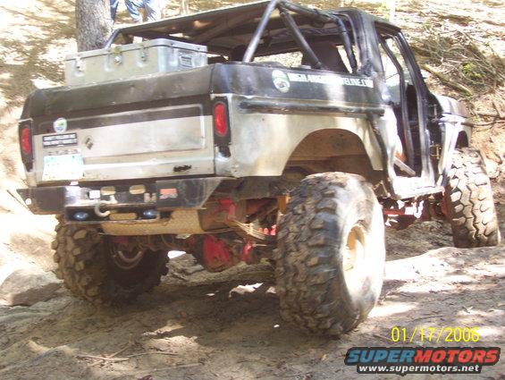 Modified SUV with large tires and roll cage, seen from rear