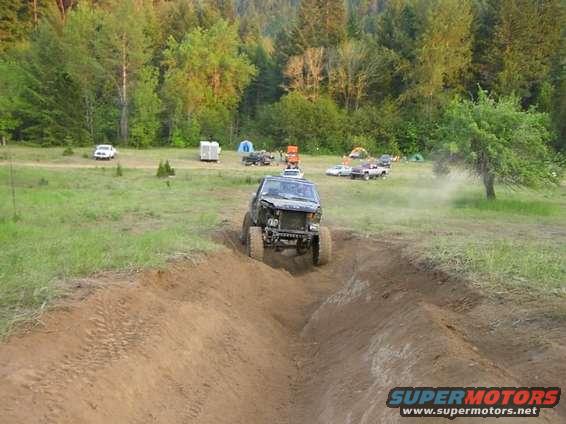 1988 Ford Bronco climbing a dirt track, front grille removed