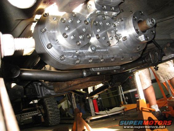 Custom aluminum transfer case with multiple bolted plates, viewed from underneath a vehicle