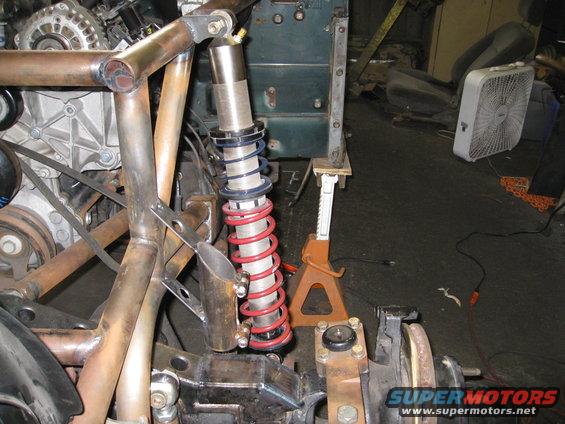 Custom suspension with red coilover shock and engine components visible