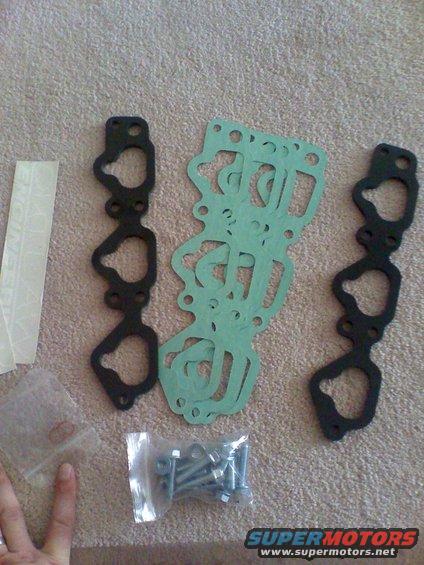 Engine gaskets and hardware laid out on a textured surface