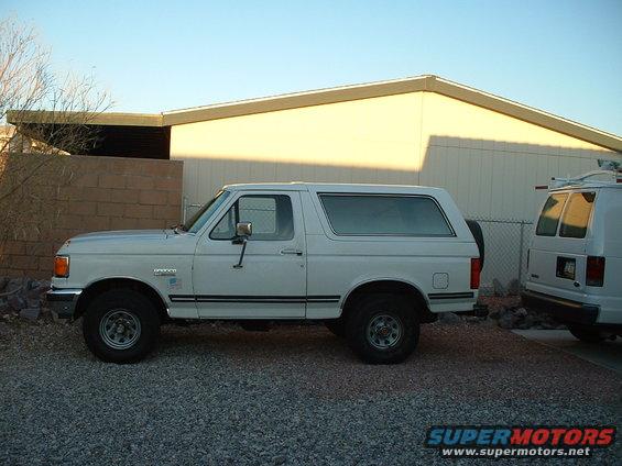 White 1991 Ford Bronco parked on gravel, side view