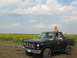 1985 Ford Bronco - Two people are in and on a black pickup truck with a sunflower field in the background.