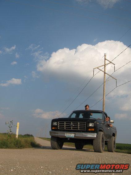 Black pickup truck with a horizontal grille and a Ford emblem, seen from the front