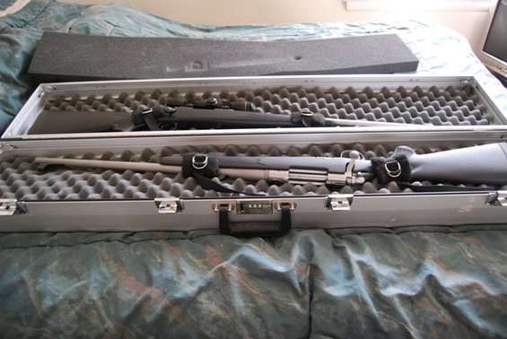 Two rifles, one with a scope, secured in a foam-lined case