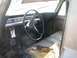 1971 International Travelall - The interior of a 1971 International Travelall shows a worn seat and dashboard with a large steering wheel.