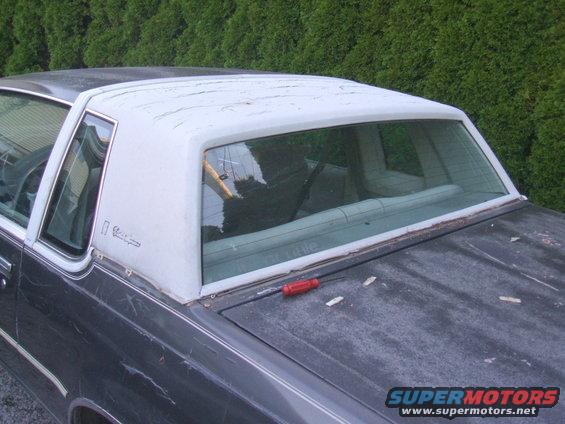Gray 1982 Oldsmobile Cutlass with white vinyl top, rear quarter view