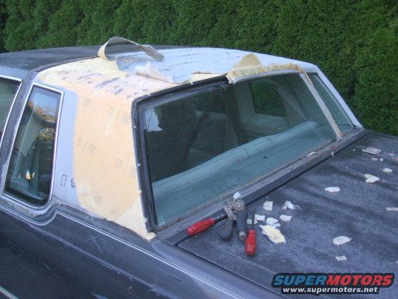 1982 Oldsmobile Cutlass roof being stripped of old vinyl top material, tools on trunk