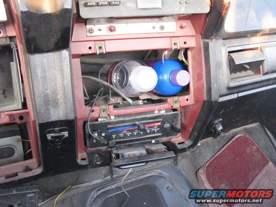 Interior dashboard with bottles in the center console and climate controls visible. 1985 Ford Bronco