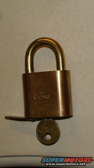 Brass padlock with Ford logo and a key inserted
