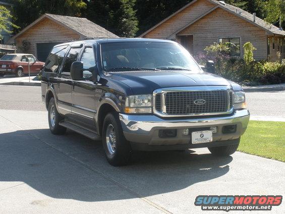 Dark blue Ford Excursion parked in driveway, front 3/4 view. License plate visible