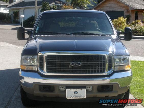 Front view of a dark blue Ford Excursion with a chrome grille and Ford logo. License plate visible