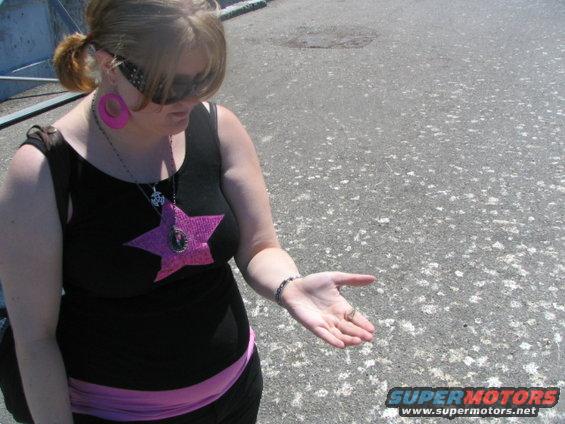 Woman in black tank top with pink star, holding hand out
