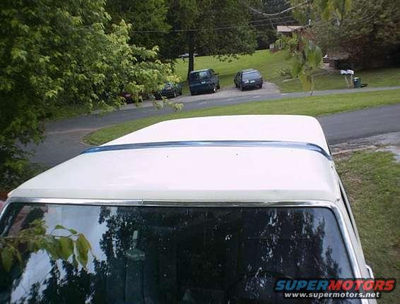 White 1986 Ford Bronco roof and windshield with other vehicles in background