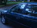 1993 Ford Taurus - Side view of a dark green 1993 Ford Taurus sedan parked on a street.