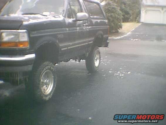 Black Ford Bronco parked on wet pavement
