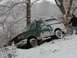 1988 Ford Bronco - A 1988 Ford Bronco is stuck in the snow near a body of water, with a person observing.