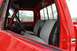 1979 Ford F-250 - The interior of a red pickup truck features a two-tone bench seat and a view through the windows.