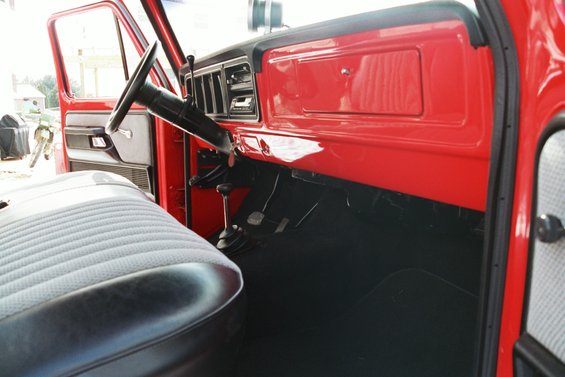Red 1979 Ford F-250 interior with bench seat and dashboard