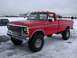 1979 Ford F-250 - Red 1979 Ford F-250 pickup truck with large tires and cab lights sits in the snow.