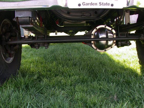 Rear axle assembly with leaf springs and shocks, showing a chrome differential cover. Garden State license plate visible