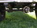 1979 Ford F-250 - Close-up of a truck's rear axle and suspension components against a grassy background.