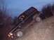 1984 Ford Bronco II - A black SUV navigates a steep dirt incline under a twilight sky.