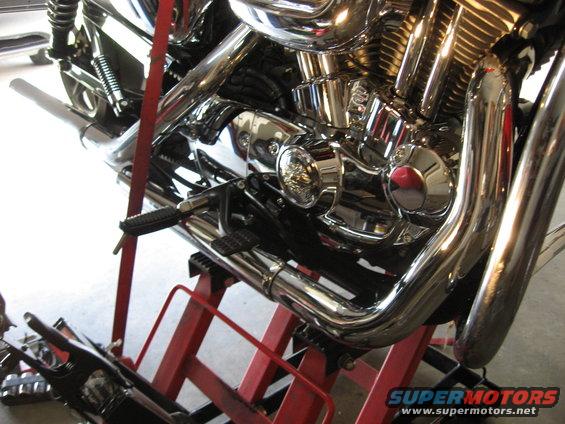 2004 Harley-Davidson Sportster Custom engine and exhaust pipes on a red lift
