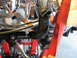 2004 Harley-Davidson Sportster Custom - A red strap is secured around the engine and frame of a motorcycle, which is on a red lift.