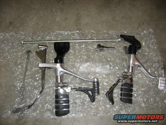 Motorcycle foot controls, including brake and shift levers with rubber grips, laid out on bubble wrap