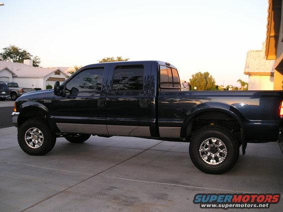 Dark blue 2001 Ford F-350 pickup truck with chrome wheels parked on a driveway