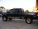 2001 Ford F-350 - Side view of a lifted 2001 Ford F-350 pickup truck with a crew cab and long bed.