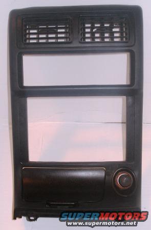 Dashboard trim panel with dual air vents, two rectangular openings, a storage compartment, and a circular knob