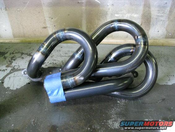 Custom exhaust headers with blue tape on one pipe