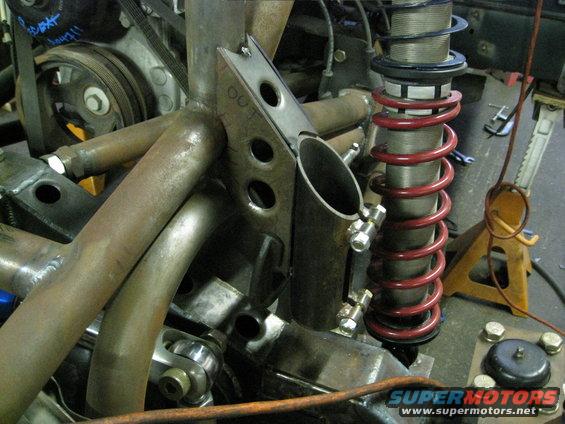 Custom exhaust manifold and red coilover suspension on a metal frame