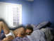 1970 Mercury Cougar - A man reclines on a bed in a room with blue walls and white plantation shutters.