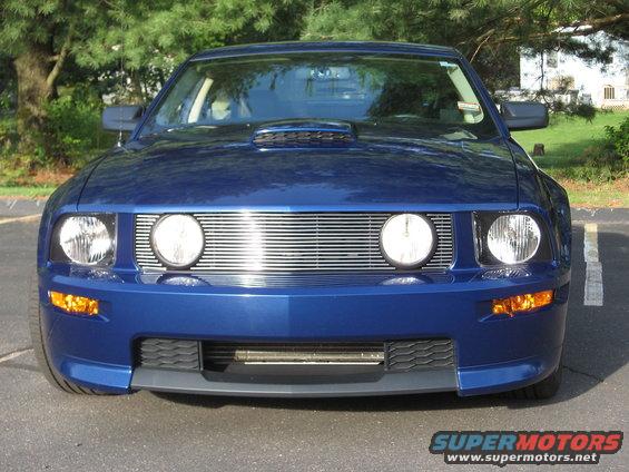 Front view of a blue 2007 Ford Mustang with a chrome grille and hood scoop