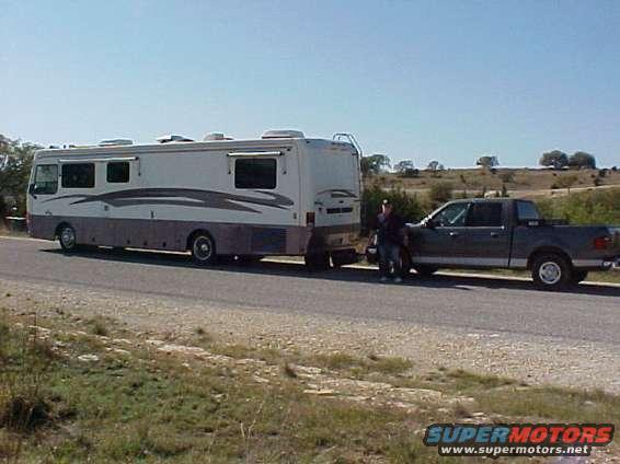 Gray pickup truck towing an RV, side view