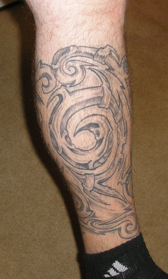 tribal tattoo on lower leg, black ink, abstract design