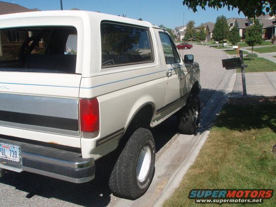 1987 Ford Bronco parked on street, rear quarter view. License plate POL 739