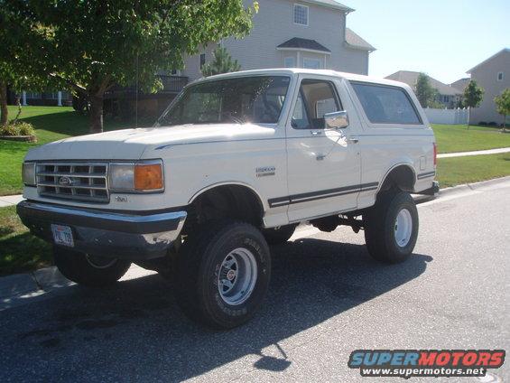 White 1987 Ford Bronco with lifted suspension and aftermarket wheels