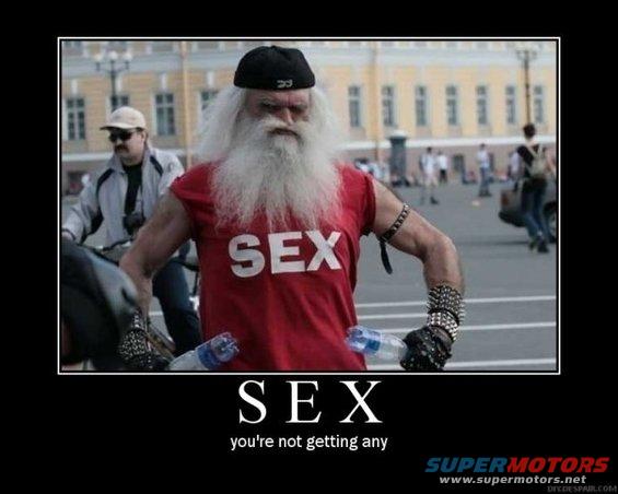 Man with white beard and red "SEX" shirt holds water bottles, wearing studded bracelets and gloves