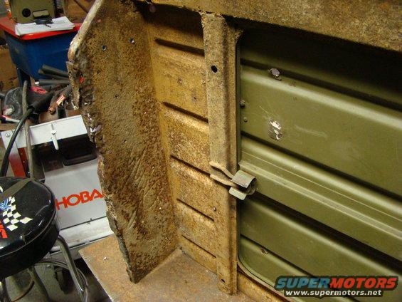 rusted metal panel with horizontal ridges and a metal latch mechanism