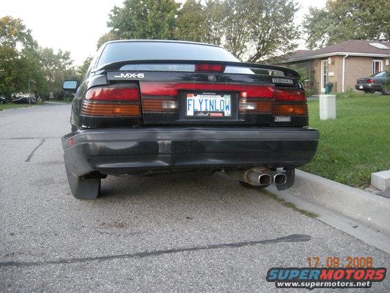 Black 1989 Mazda MX-6 with a spoiler and dual exhaust pipes