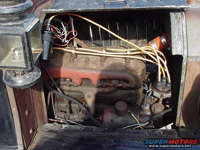 1913 Ford Model T engine bay with distributor, spark plug wires, and lamp